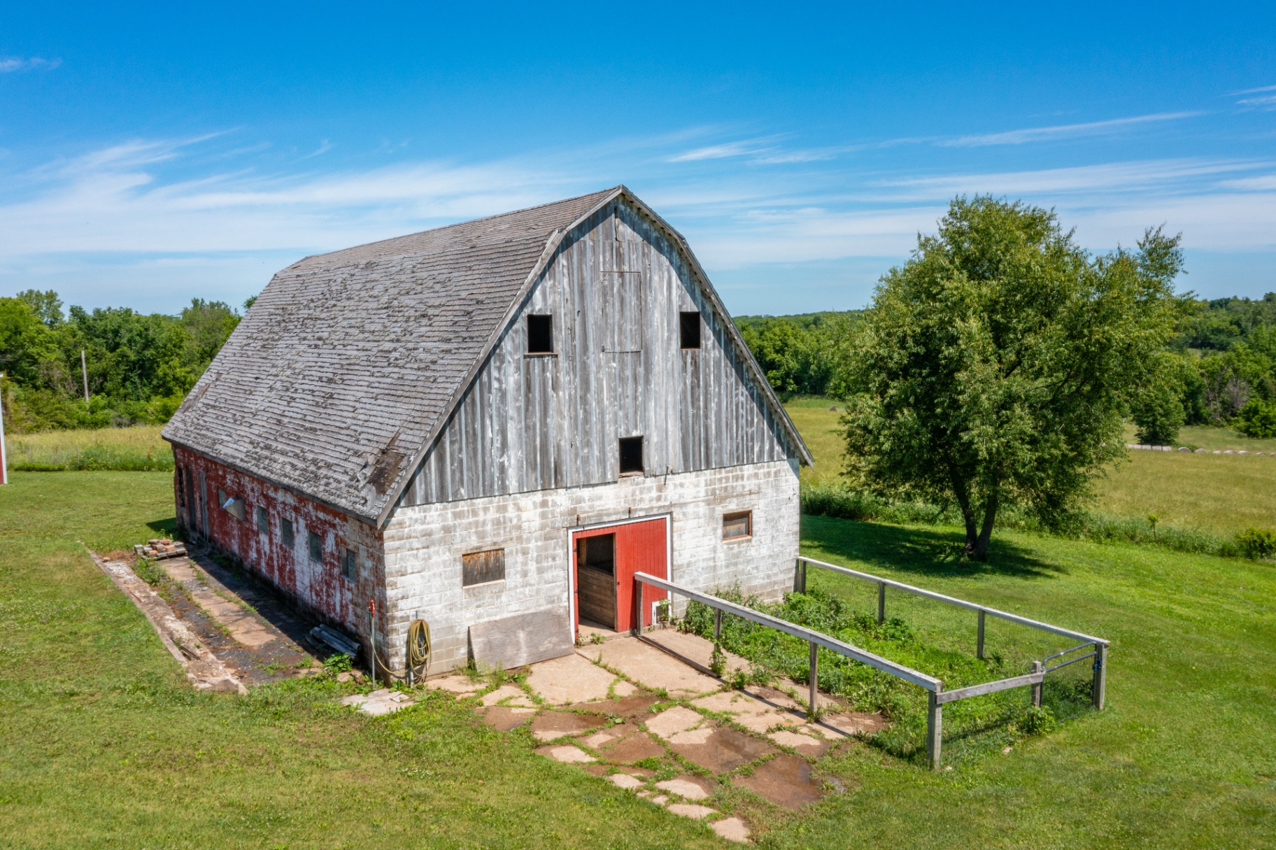 Historic gambrel-roof barn with red trim and pasture