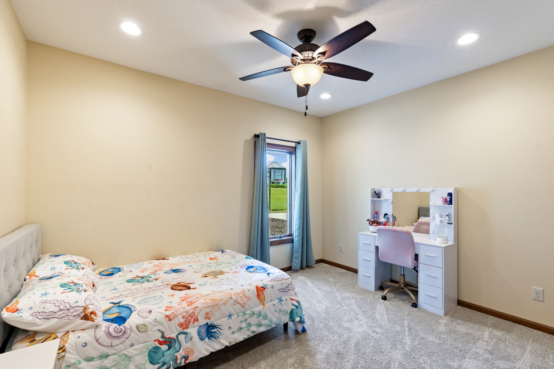 Guest bedroom with vanity desk and bright window