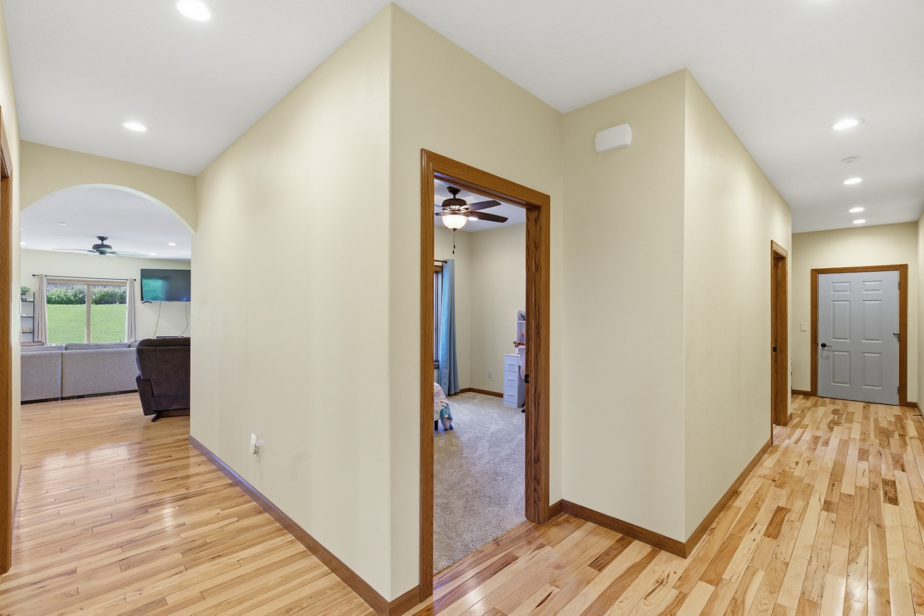 Wide hallway with hardwood floors leading to bedrooms