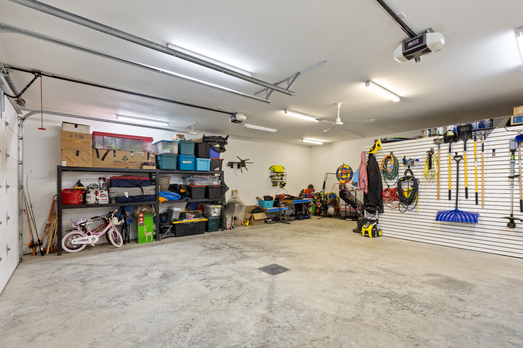 Three-car garage with storage shelving and wall organization