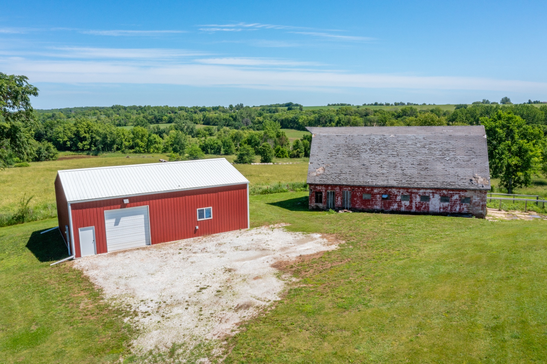 Red metal pole barn shop next to the historic barn