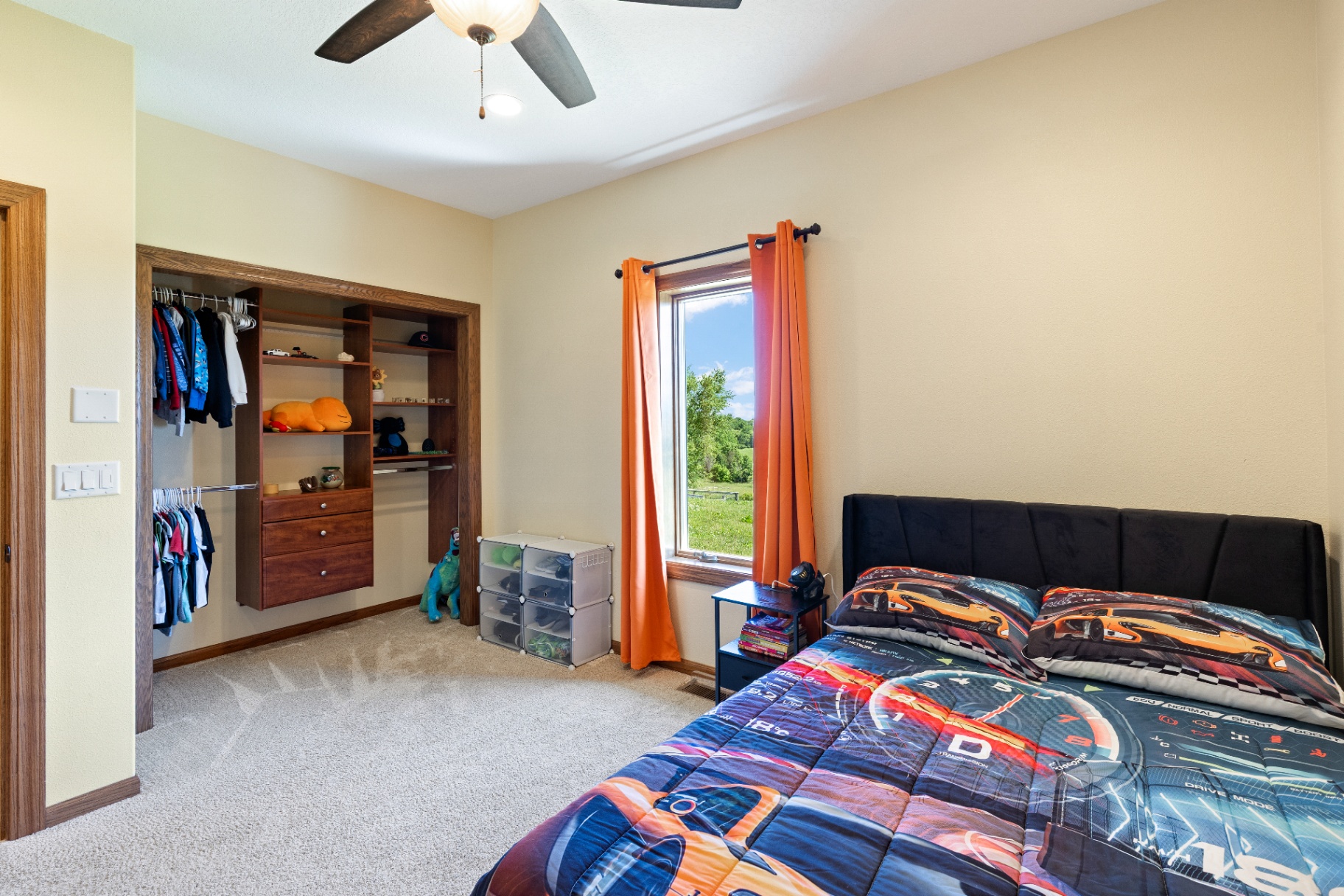 Bedroom with open closet and large backyard-facing window