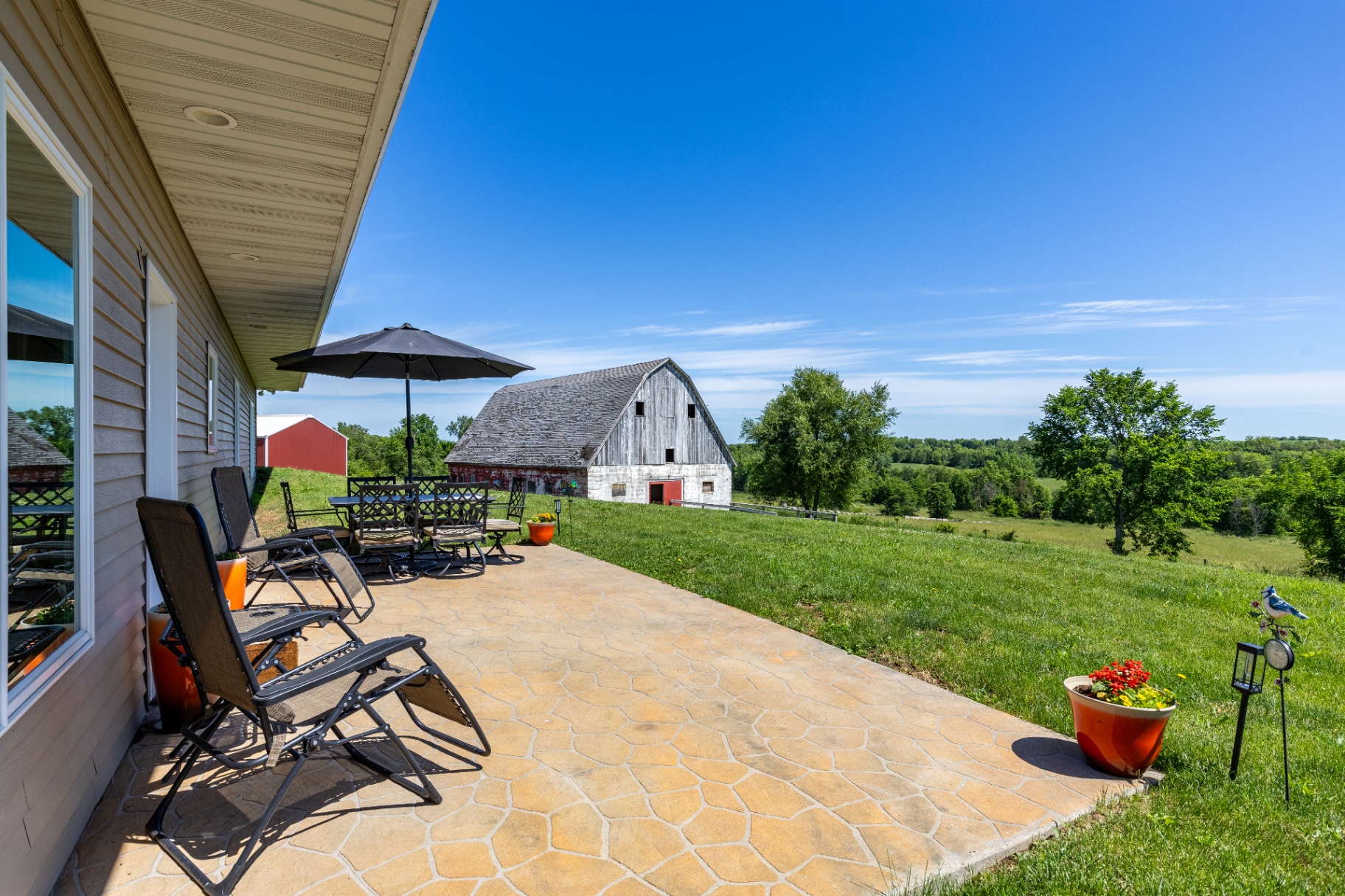 Covered patio overlooking the vintage barn and rolling countryside