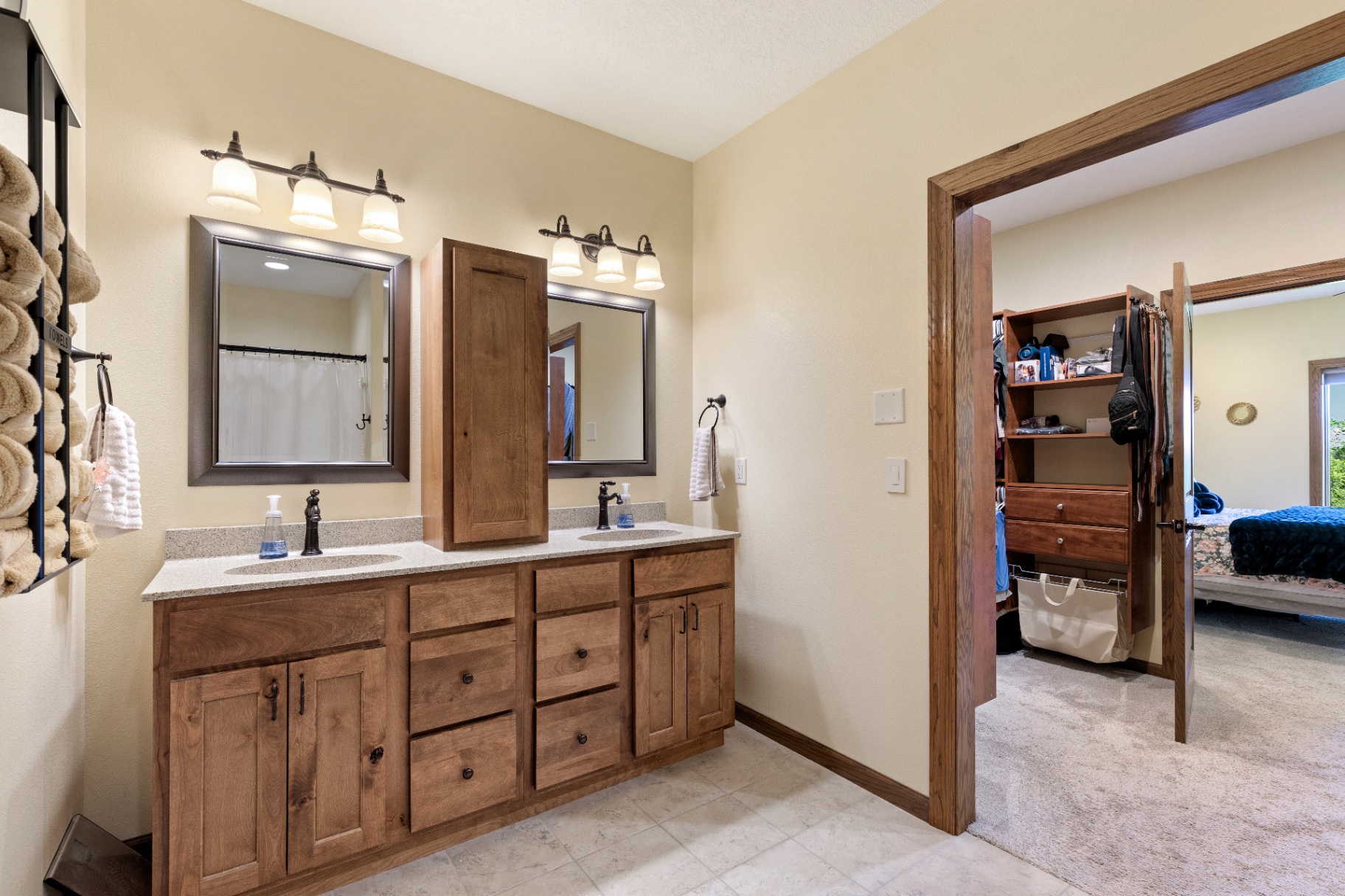 Primary ensuite with double vanity and walk-in closet beyond