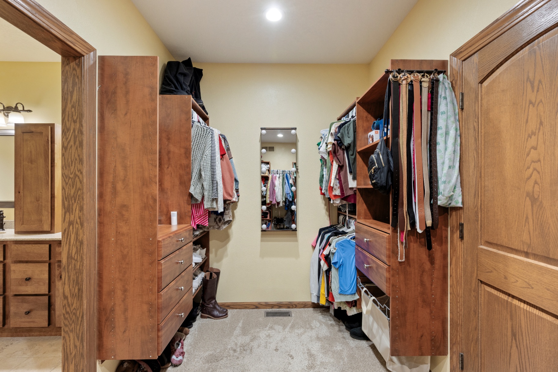 Walk-in primary closet with custom built-in shelving and drawers