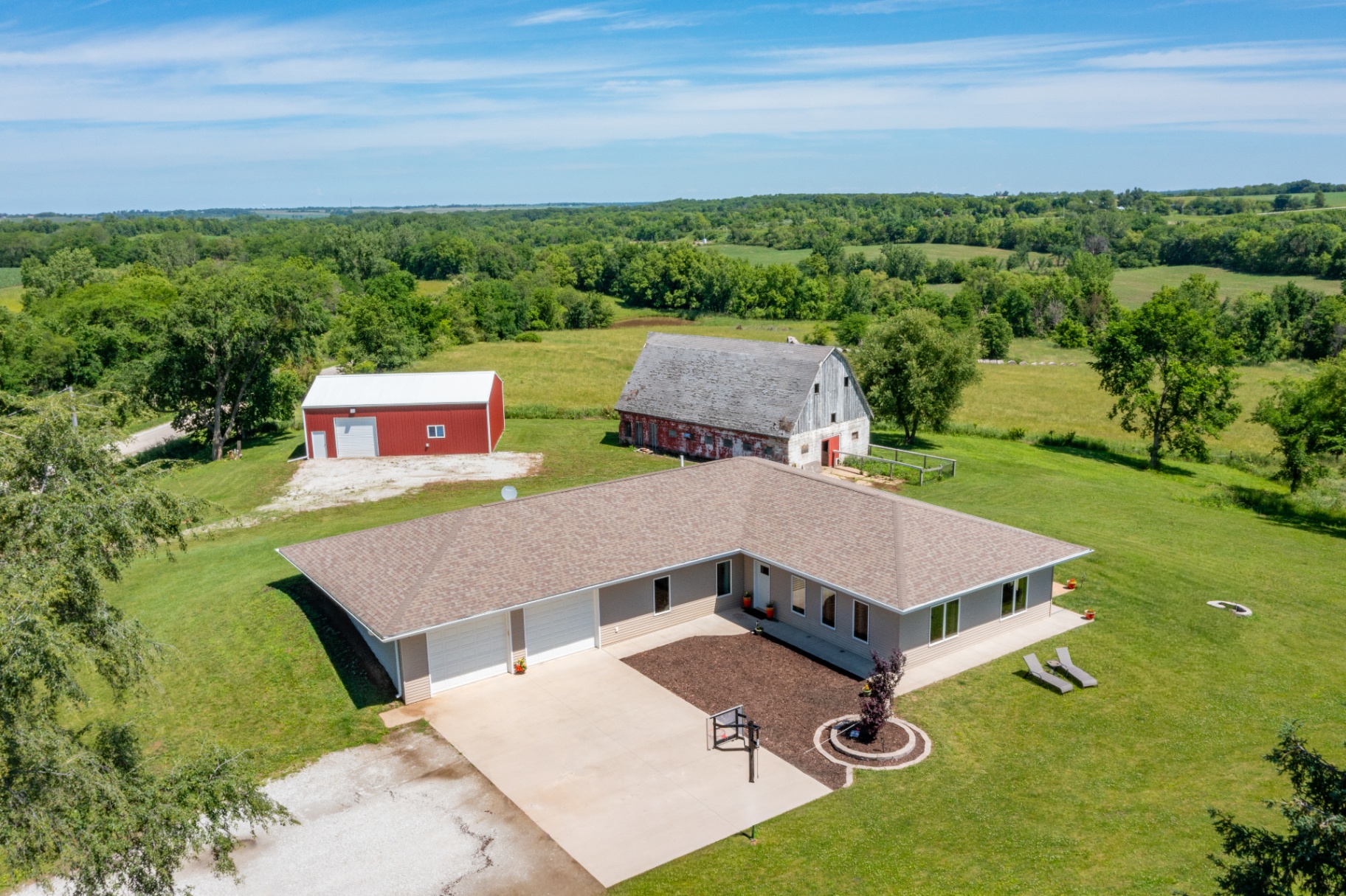 Aerial of the home, shop, and barn with countryside views