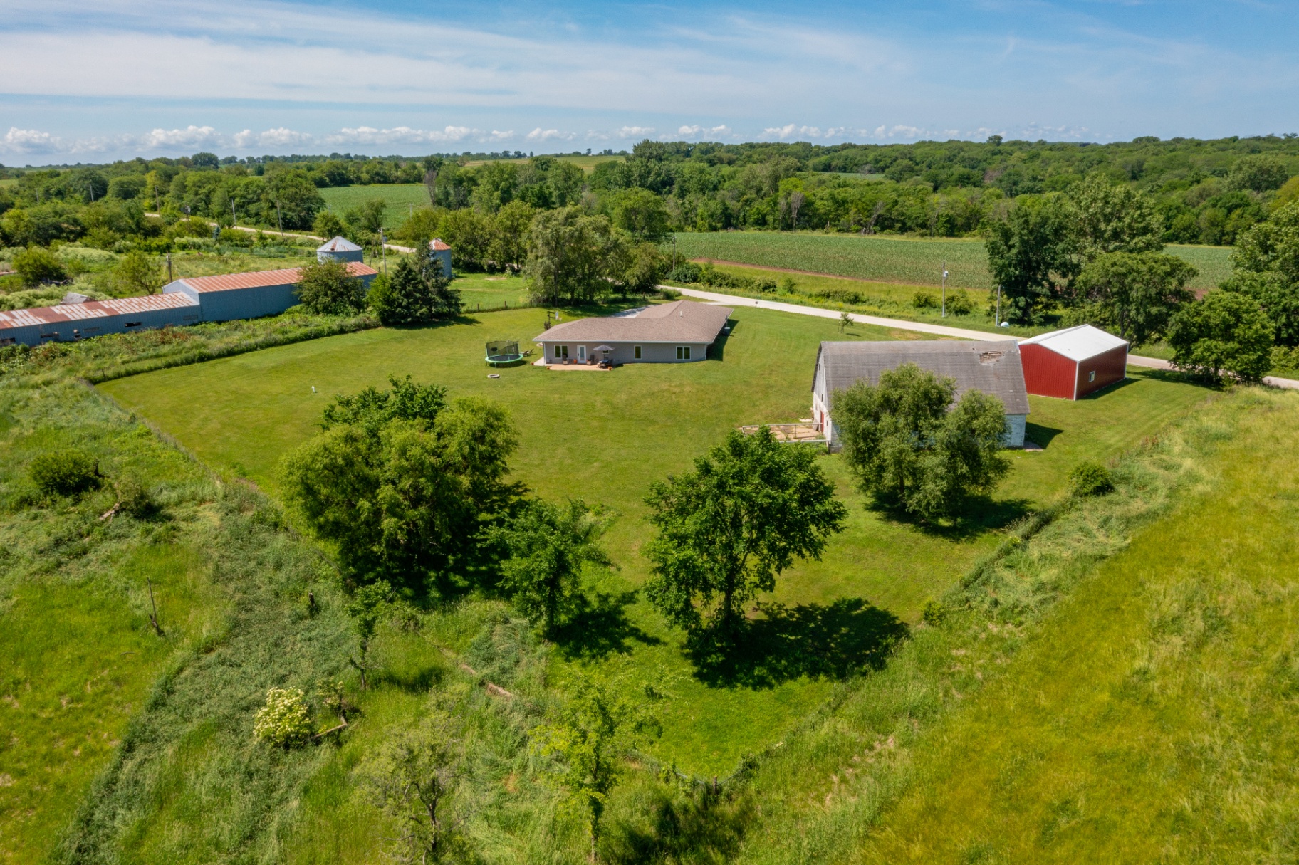 Aerial overlooking the back of the property and neighboring acreage