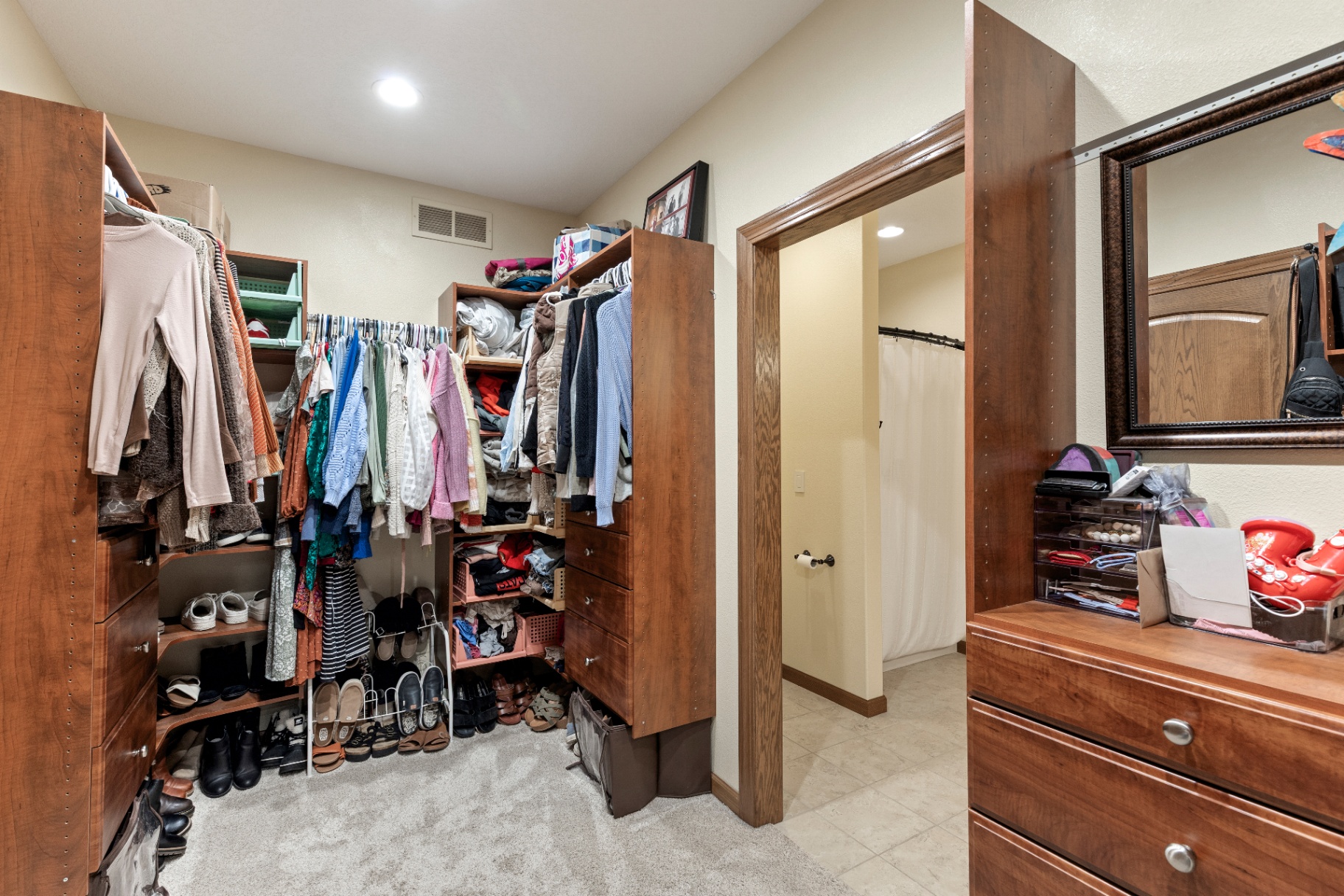 Primary closet leading toward the bathroom vanity area