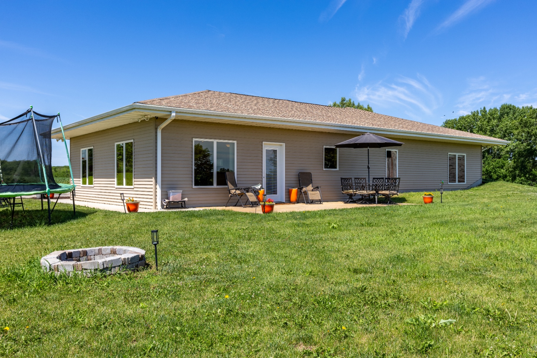 Rear exterior of the ranch home with patio seating