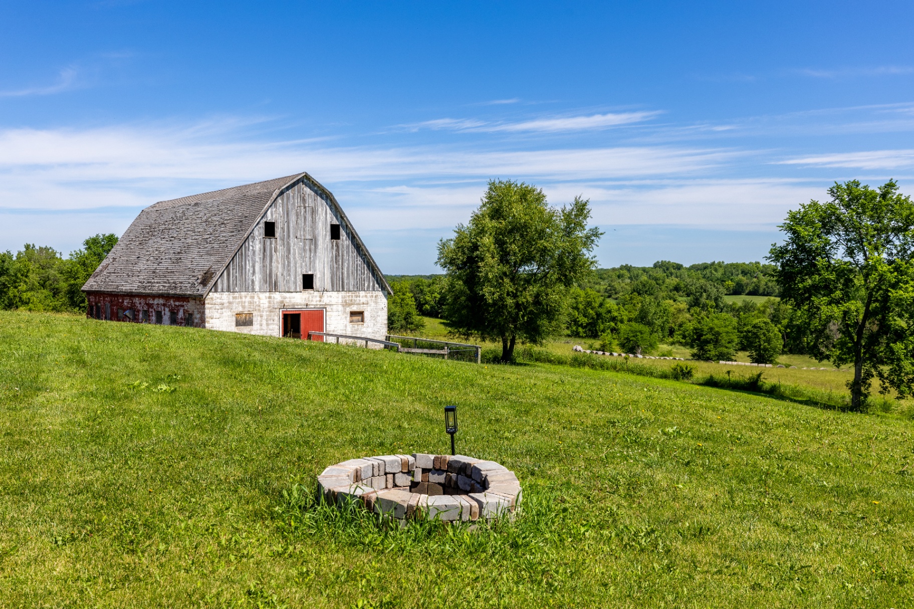 Fire pit and weathered barn set against open pasture views