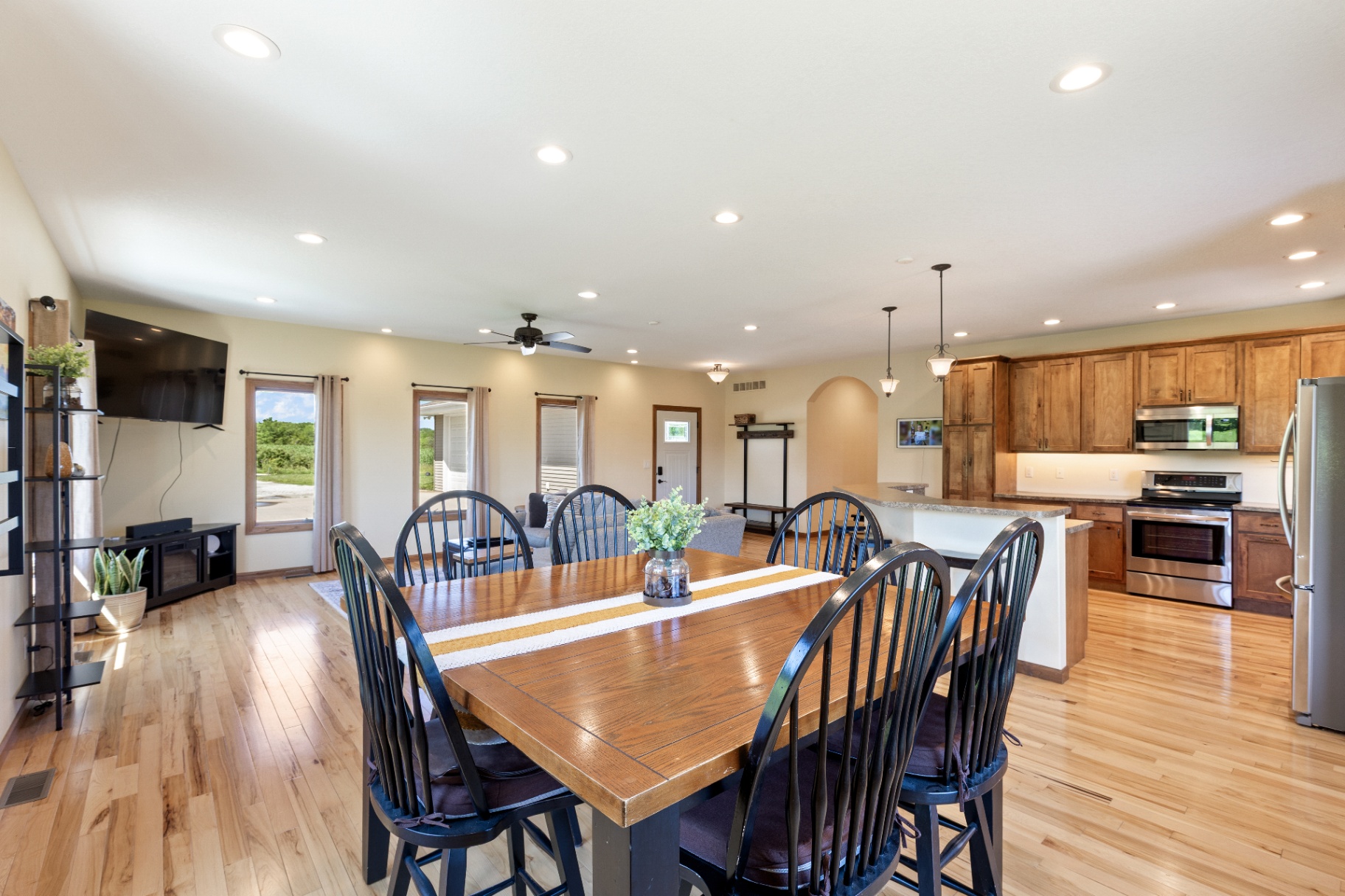 Dining table set in the open great room with kitchen beyond